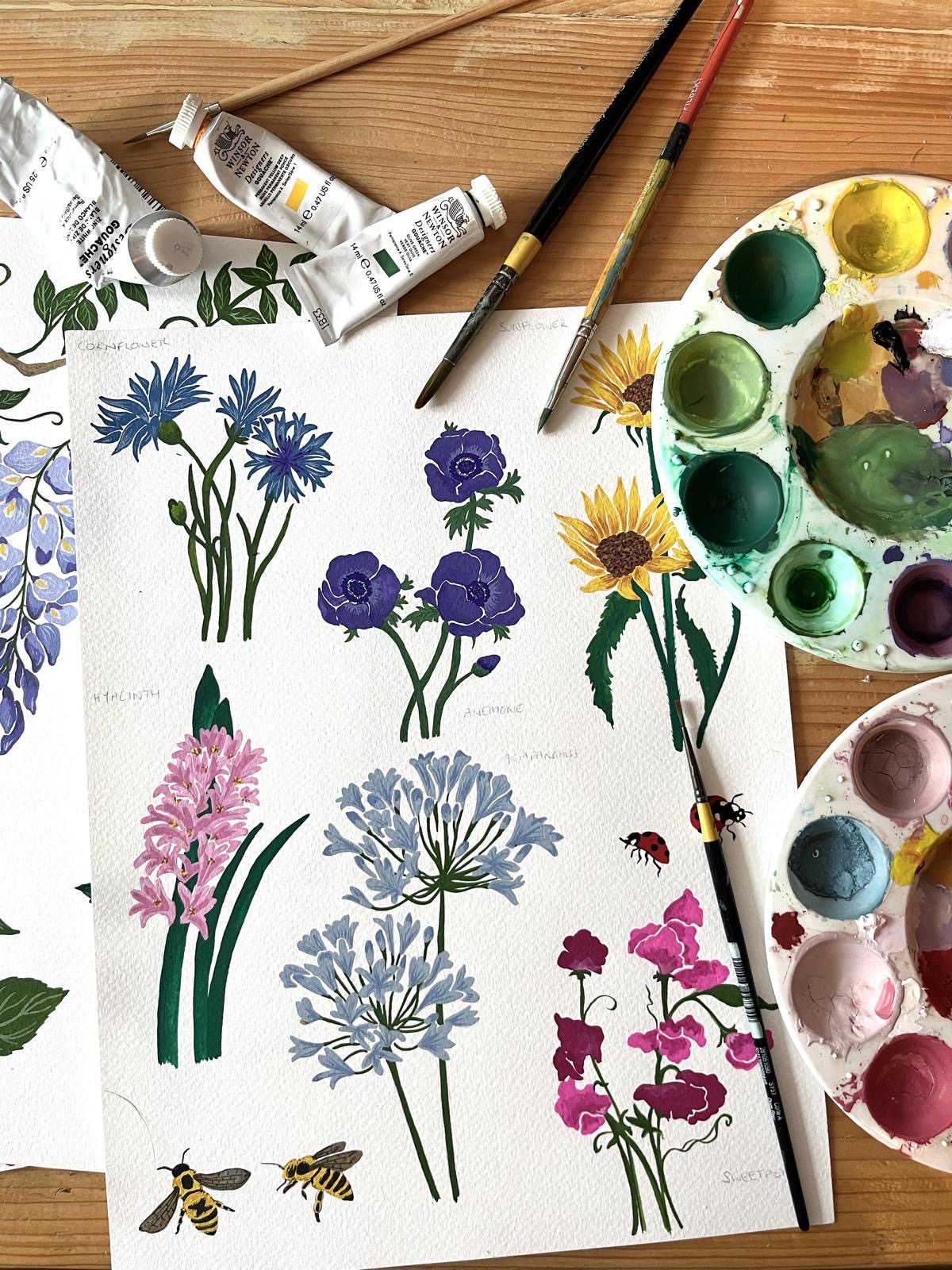 Gemma Helm’s hand painted flowers and bees alongside her paintbrushes and palette