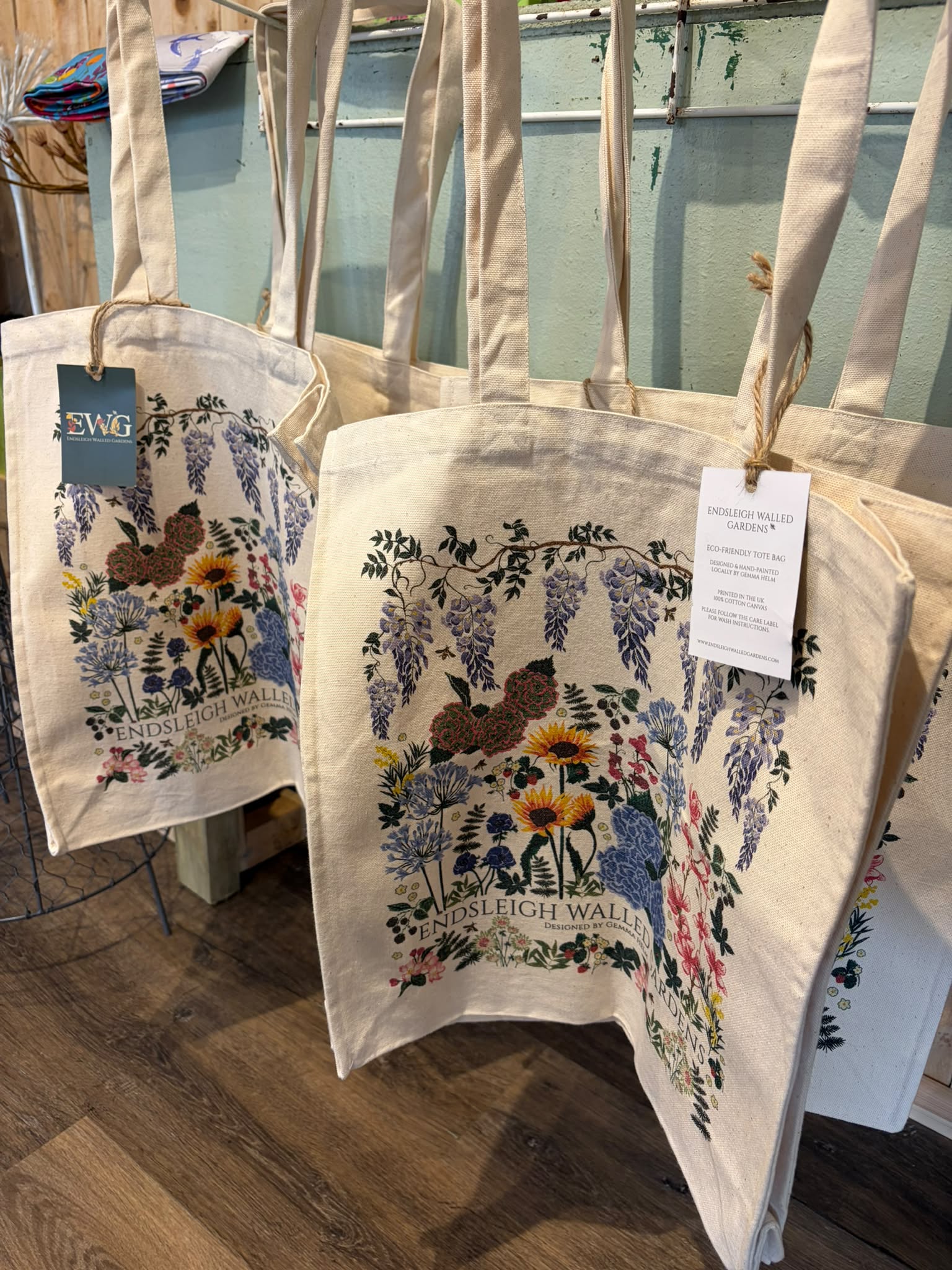 Canvas tote bags displaying Gemma Helm’s floral Endsleigh Walled Gardens design