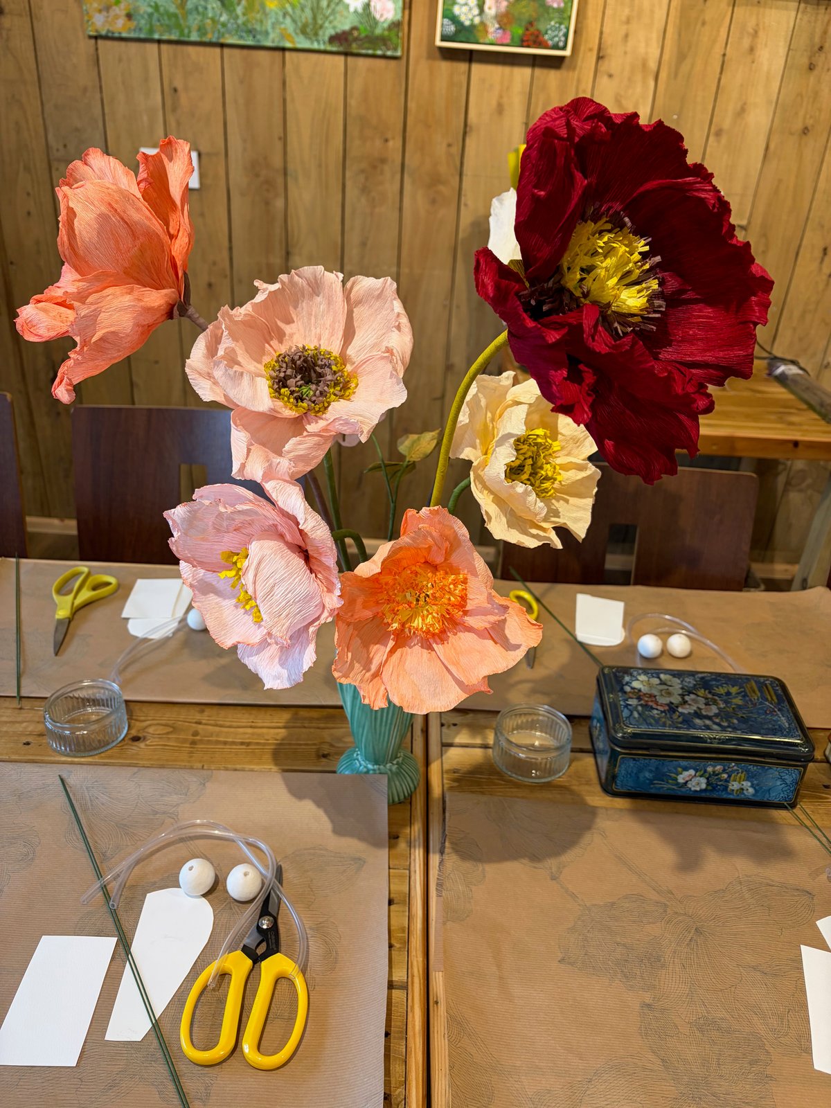A colourful bouquet of handmade crepe paper flowers on the workshop table